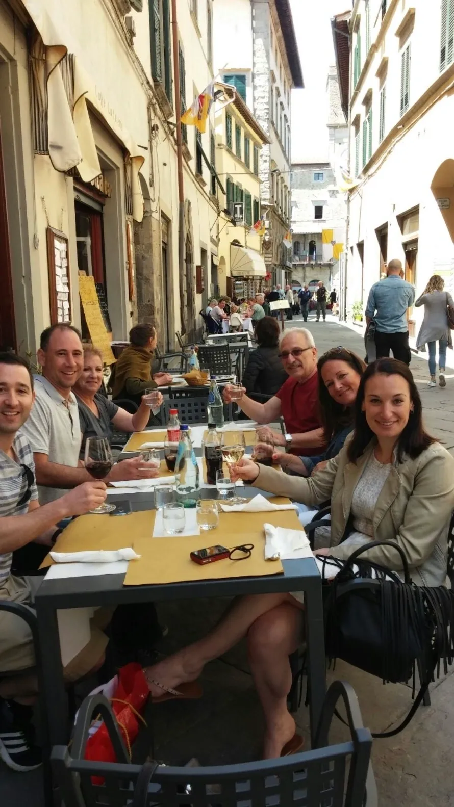 Group of friends dining outdoors at a street cafe.